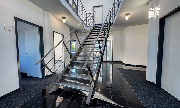 Moderne Treppe im Business Center „Herkner Straße“ mit angrenzenden Räumen und Metallgeländer 