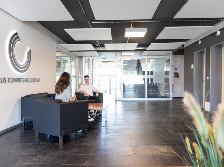 Grieb Immobilien Foyer Personen sitzen im Foyer eines Bürogebäudes