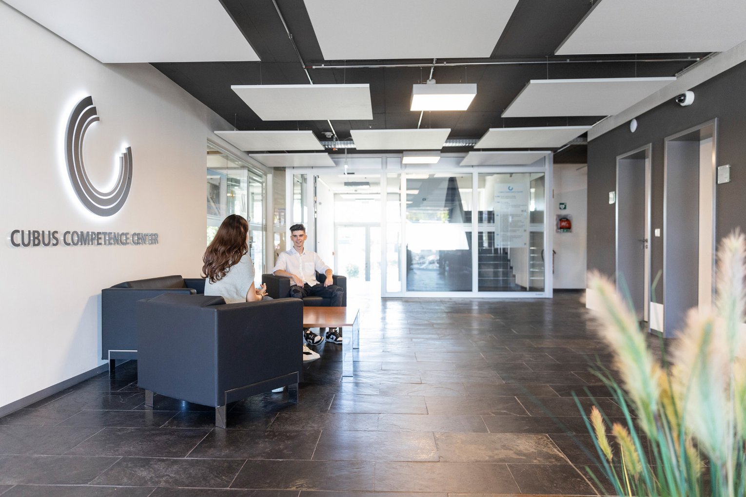 Grieb Immobilien Foyer Personen sitzen im Foyer eines Bürogebäudes